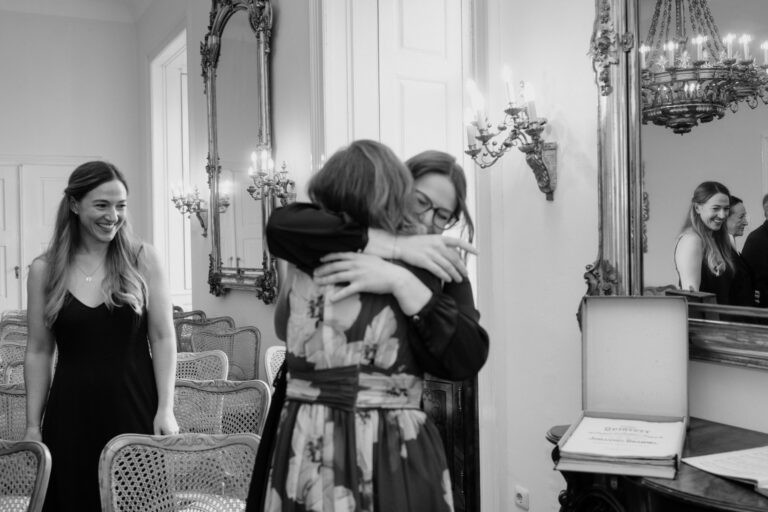 Zwei Frauen umarmen sich herzlich bei der Standesamtlichen Hochzeit, Freude und Zusammenhalt im Mittelpunkt.